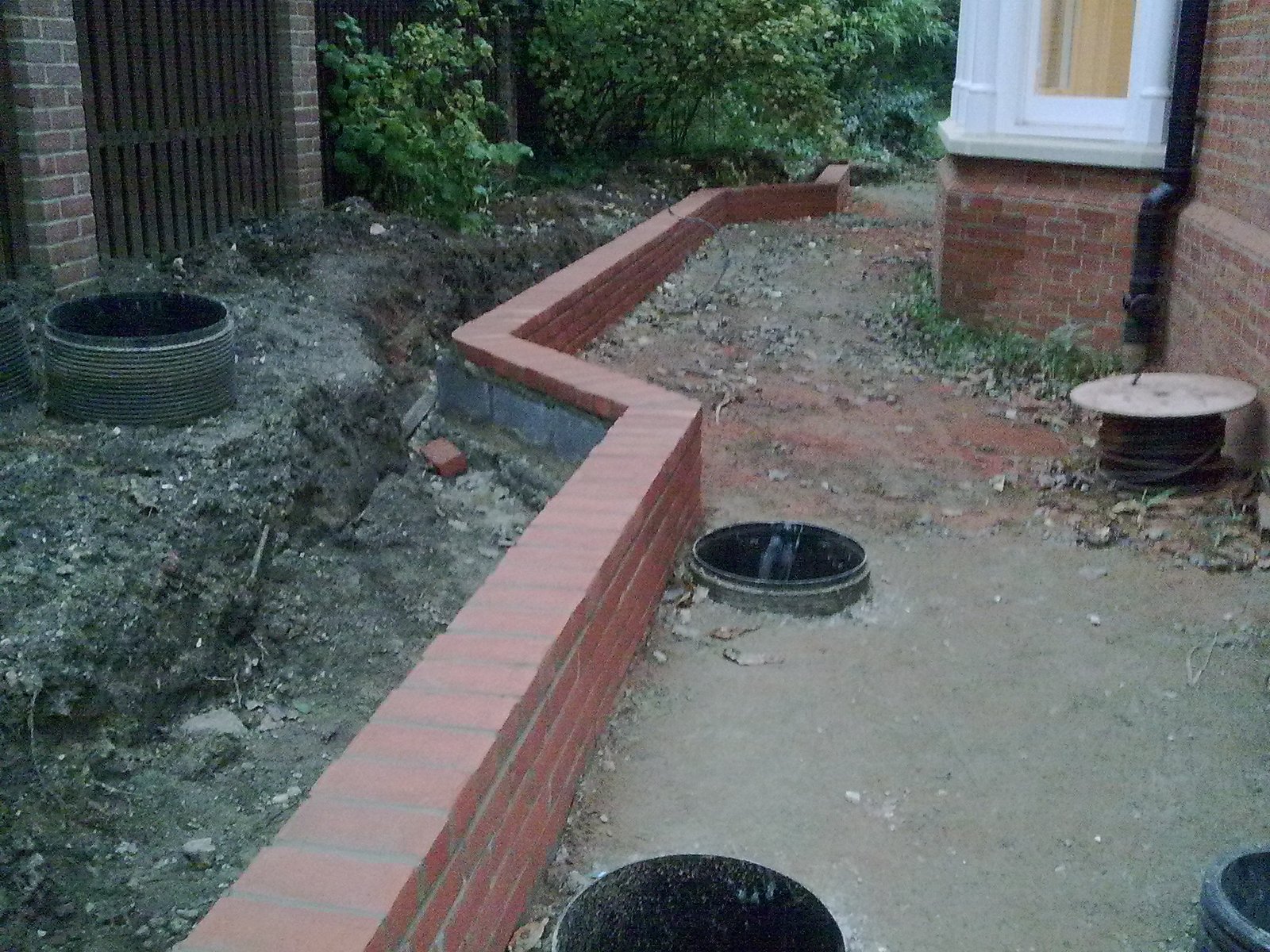 Red brick retaining walls, paving and lawn irrigation in South Farnham