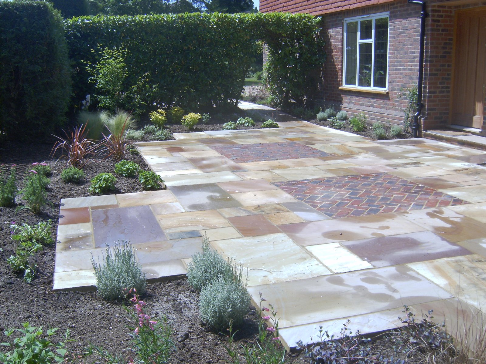 Indian sandstone paving with brick infills and pergola