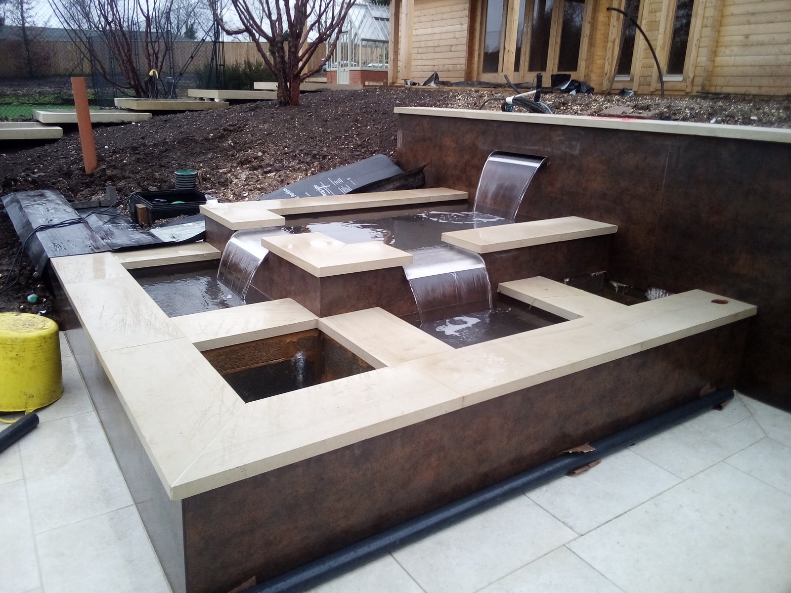Modern garden in Farnham with large-format tiles, water feature and steps