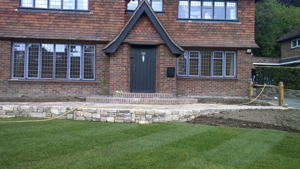 Natural stone wall with chestnut fencing in Haslemere